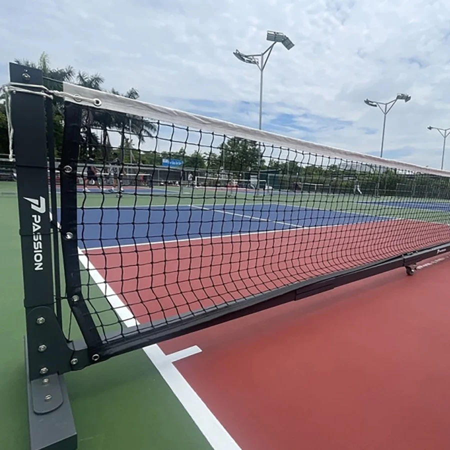 Lưới Passion Pro dựng trên sân pickleball ngoài trời mặt sân đỏ và xanh